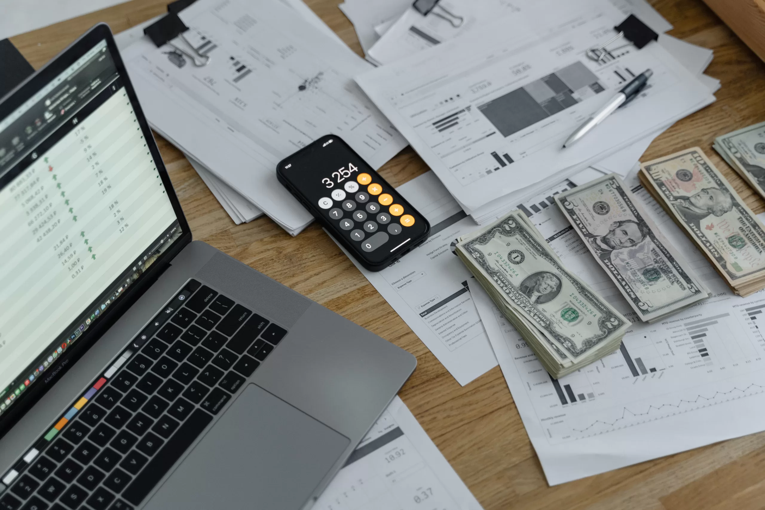 A laptop on a table together with money to represent profit to change Cypress for AI