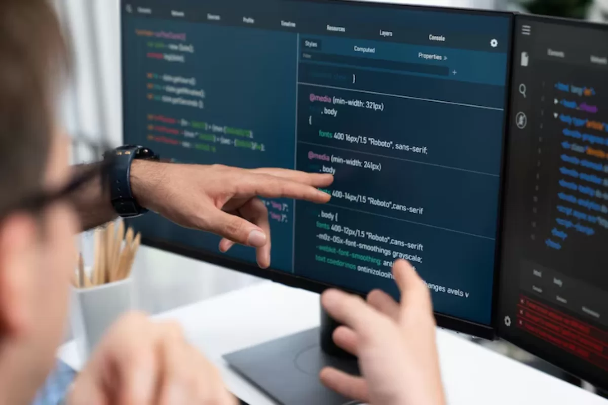 Two man pointing to a computer screen