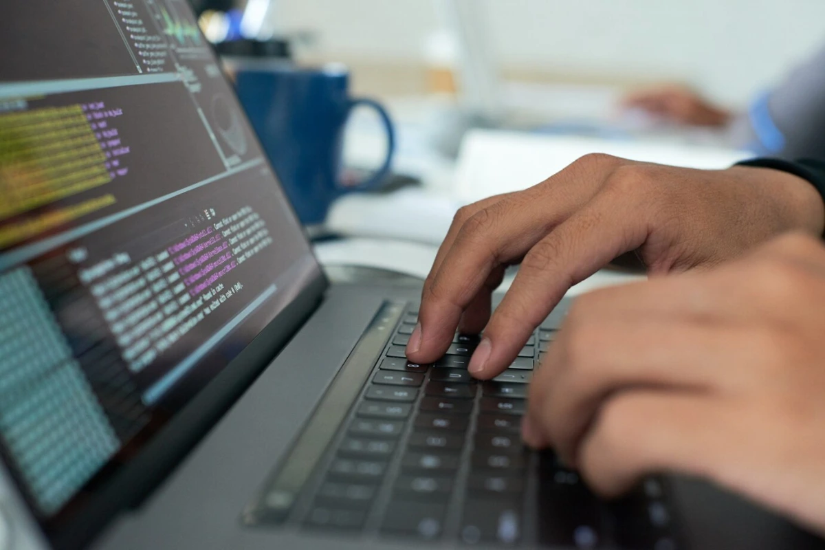 Hands coding in a laptop