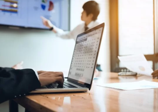 Mão digitando em um notebook, representando um analista de QA