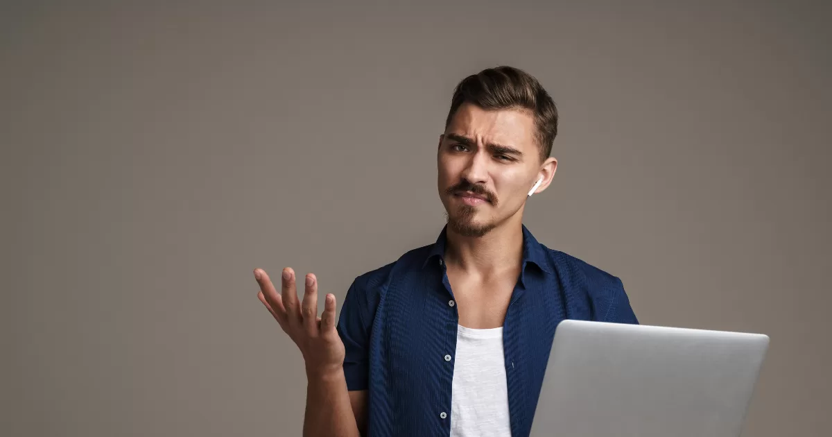 Imagem de um homem confuso segurando um notebook devido a testes flakey