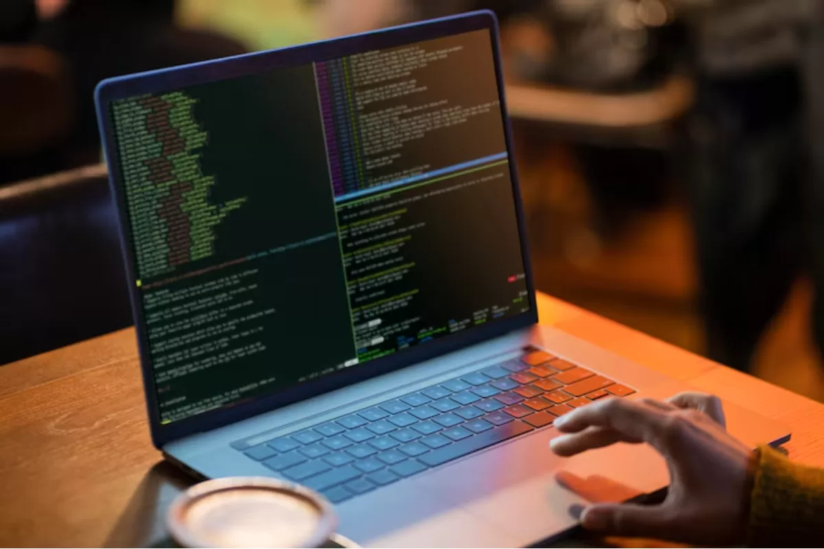 Imagem de um computador mostrando códigos na cor verde na tela