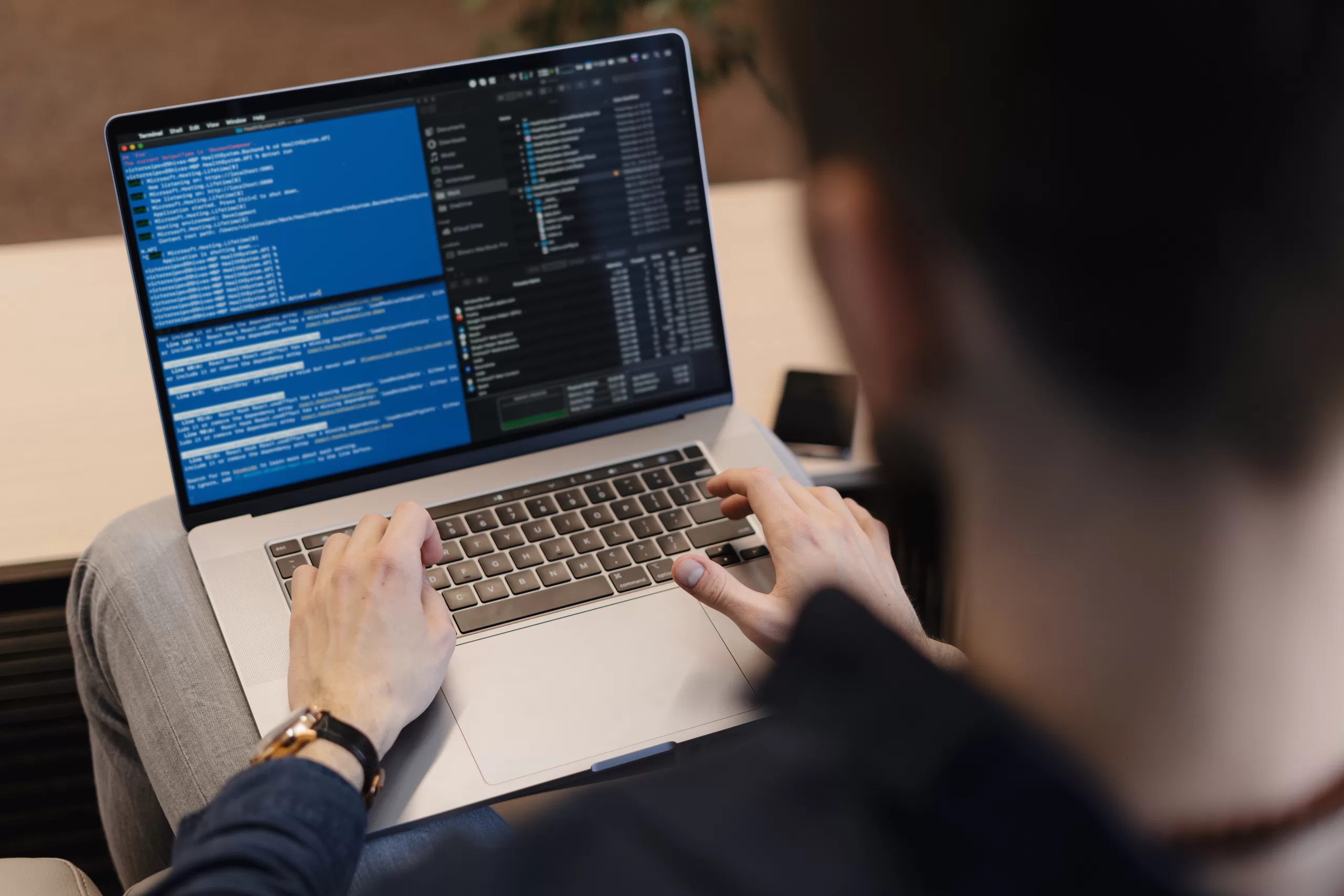 Developer writing code on a laptop with terminal and file explorer open on the screen, representing API test flows