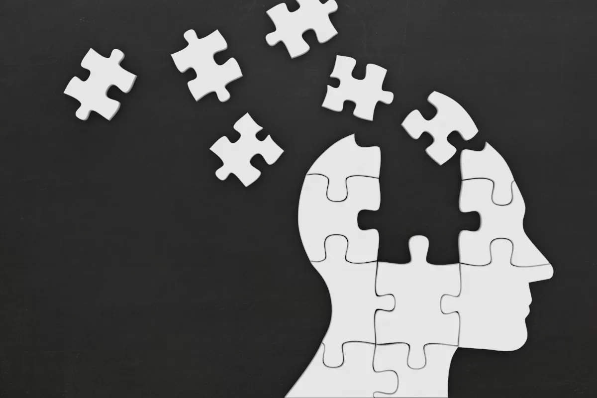 Puzzle pieces forming a human head, representing the concept of memory in AI agents.