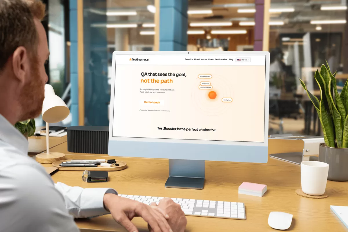 Developer looking at a monitor displaying the TestBooster.ai website
