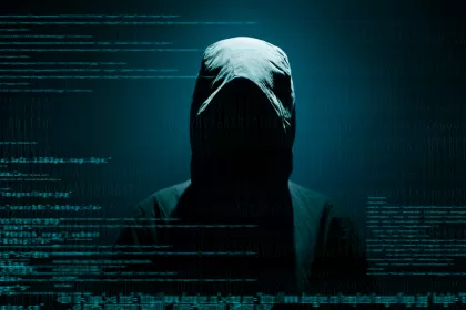 Figura encapuzada com código sobreposto, representando hacker, risco de segurança digital e pentest.