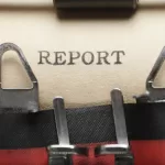 Máquina de escrever vintage com papel mostrando a palavra 'REPORT' digitada, simbolizando a escrita de bug report