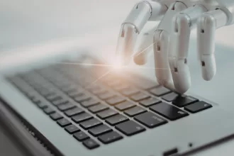 Mão robótica digitando em um teclado de computador