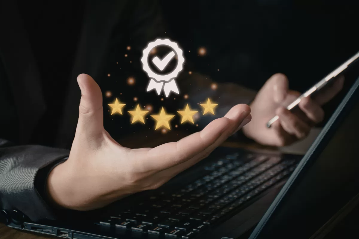 Professional using laptop with quality seal icon and golden stars floating above hand, symbolizing quality and excellence in software testing from the beginning of development